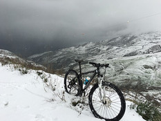 Vélo dans la neige avec vue sur les montagne.